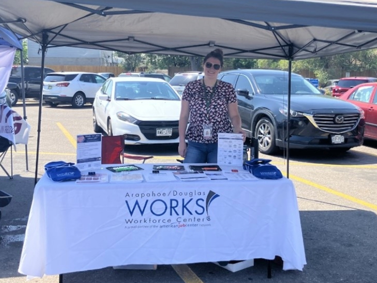 A/D Works! staff member standing behind resource table