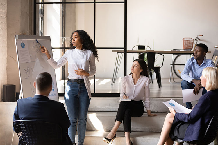 African businesswoman manager give presentation on whiteboard at office meeting