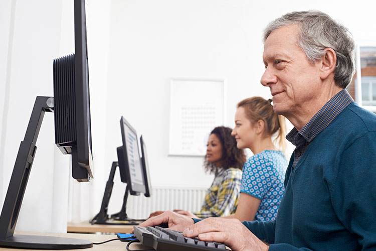 Mature man attending computer class