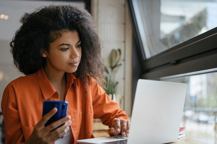 Empresaria pensativa escribiendo, lluvia de ideas, sentado en la oficina moderna. Retrato de mujer autónoma con ordenador portátil trabajando en casa